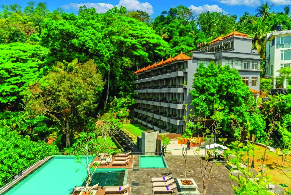 A hillside hotel with pools surrounded by forest in Kandy